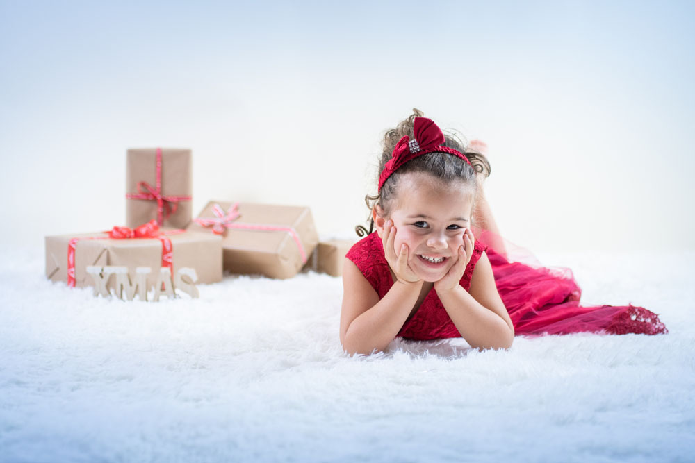 petite fille en robe rouge avec décor de Noël Emilie Champeyroux Photographies Auvergne Riom Aigueperse
