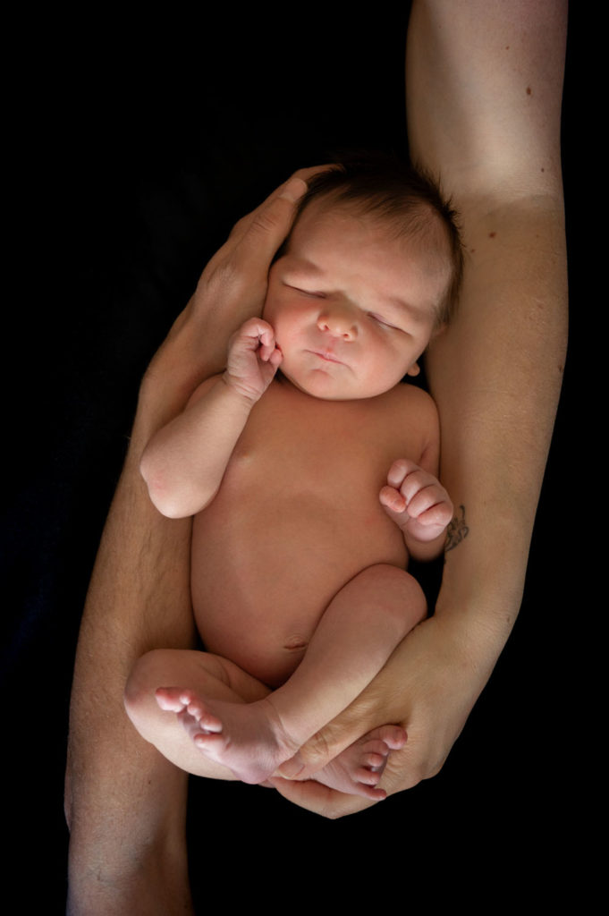 Bébé qui dort dans les bras de ses parents Emilie Champeyroux Photographies Auvergne Riom Aigueperse