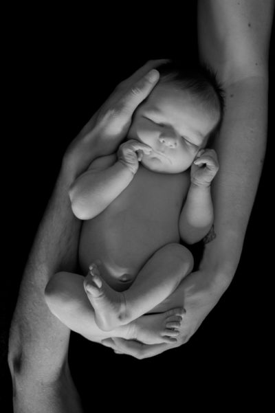 Bébé qui dort dans les bras de ses parents Emilie Champeyroux Photographies Auvergne Riom Aigueperse