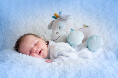 Bébé qui sourit en dormant avec peluche Emilie Champeyroux Photographies Auvergne Riom Aigueperse