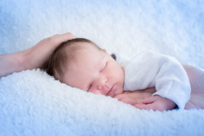 Bébé qui dort avec mains de maman et papa Emilie Champeyroux Photographies Auvergne Riom Aigueperse