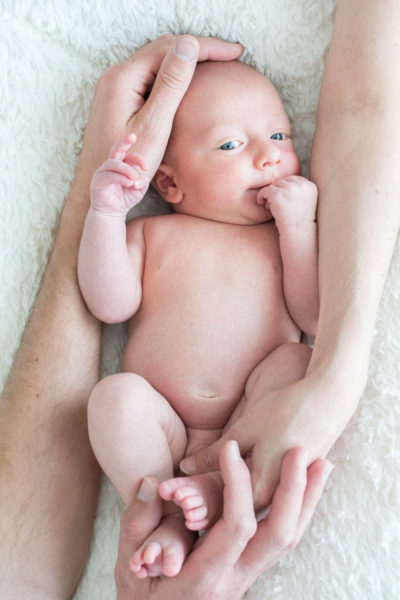 Bébé dans les bras de ses parents Emilie Champeyroux Photographies Auvergne Riom Aigueperse