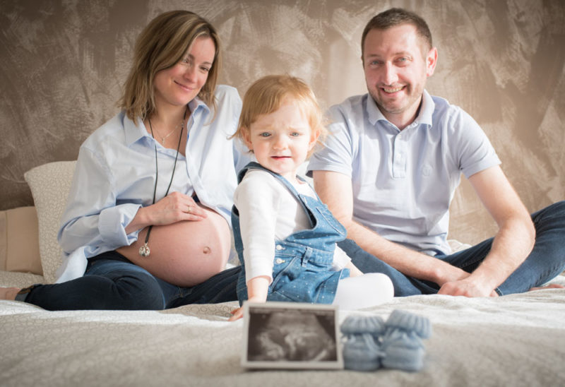 Famille sur le lit avec échographie grossesse Emilie Champeyroux Photographies Auvergne Riom Aigueperse