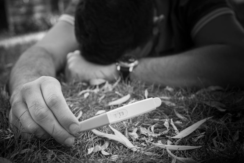 Annonce heureux évènement avec test de grossesse Couple avec femme enceinte dans champ de blé Emilie Champeyroux Photographies Auvergne Riom Aigueperse